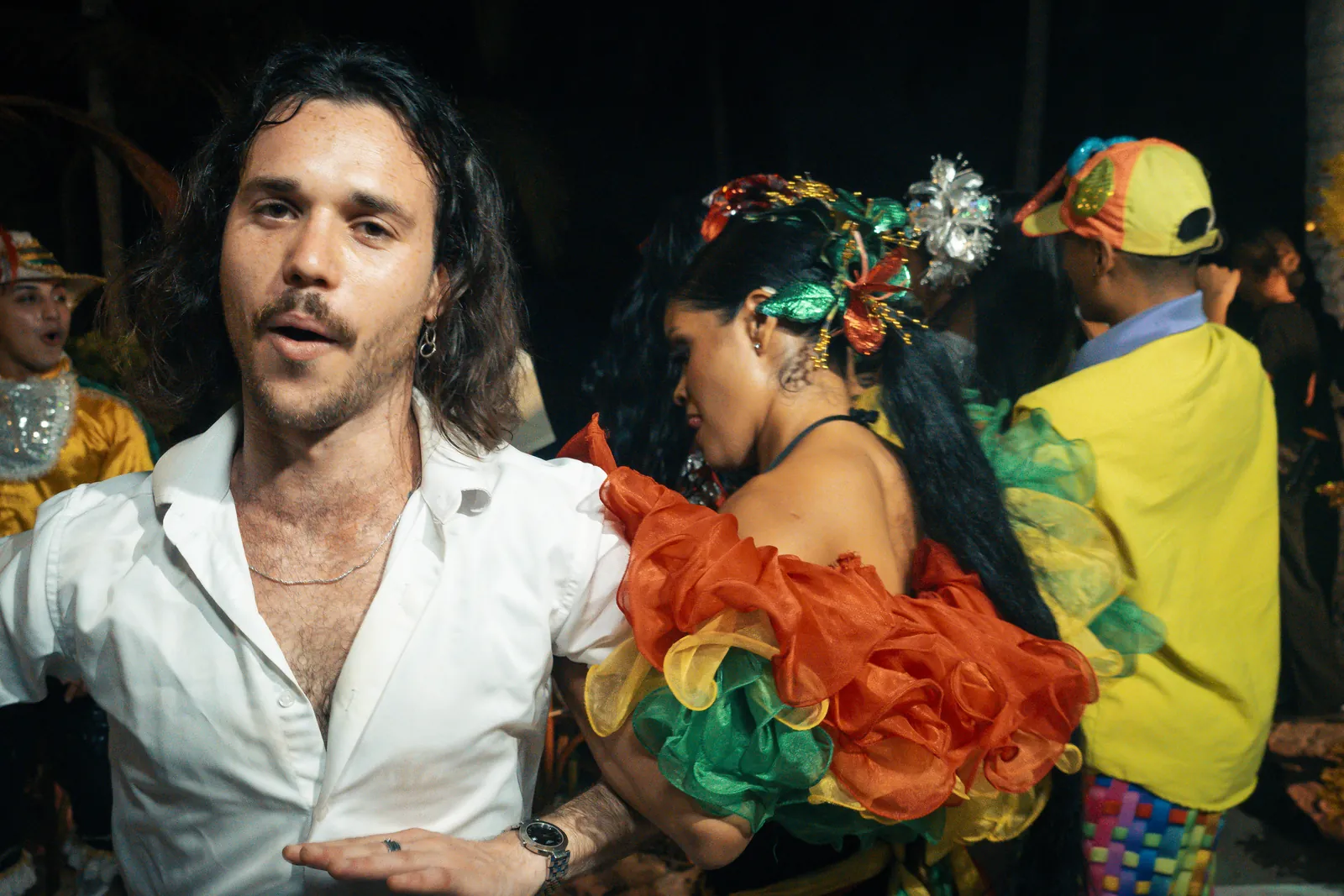 Wedding guests dancing with costumed carnival performers during an hora loca
