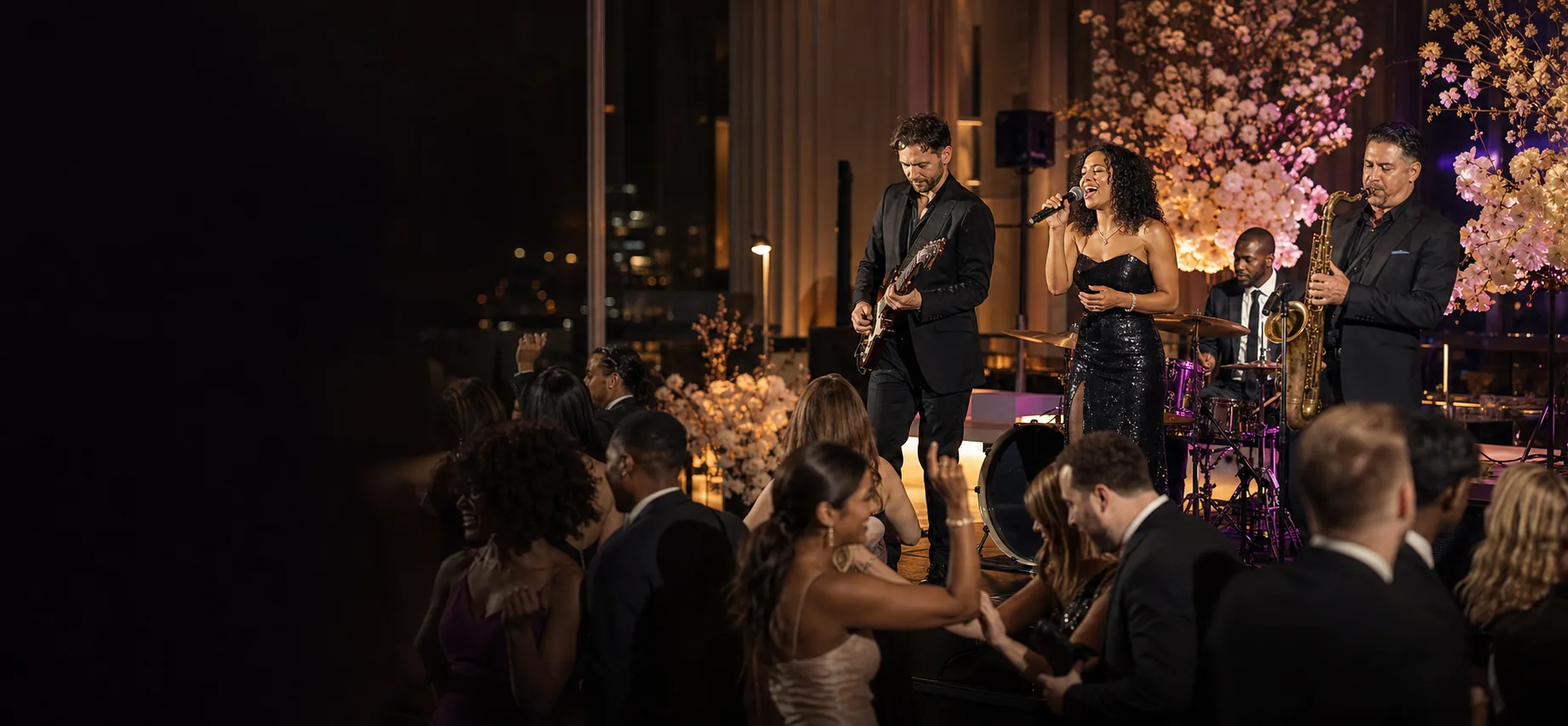 Live vocalist, saxophonist, guitarist and drummer performing for dancing wedding guests in an elegant Toronto event space